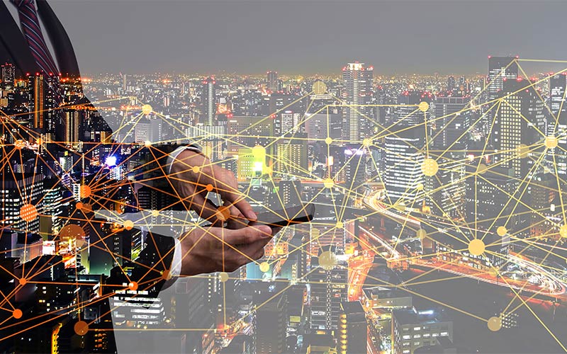 Businessman using smartphone on city background with connected polygonal dots